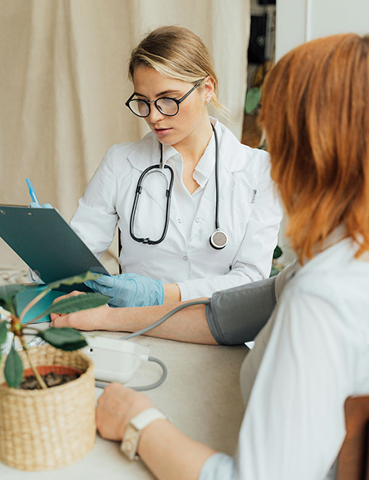 female physician checking a patient's blood pressure