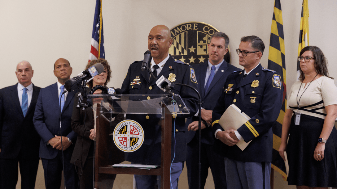 speaker standing at a podium during a police press conference